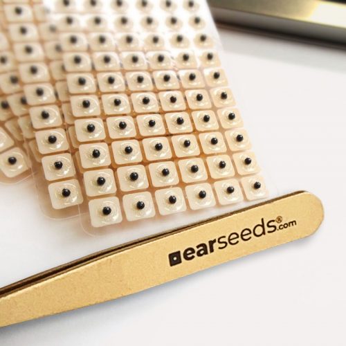 close up of ear seeds tweezers